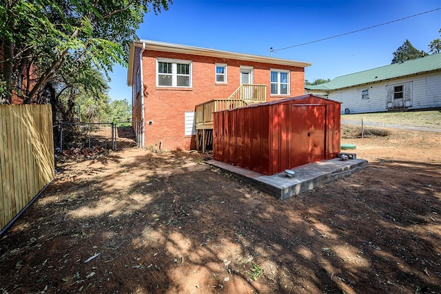 rear view of property featuring a storage unit