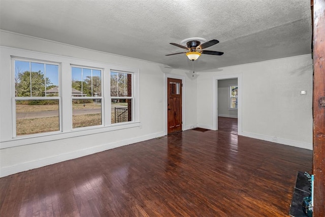 empty room featuring a textured ceiling, dark hardwood / wood-style floors, and ceiling fan