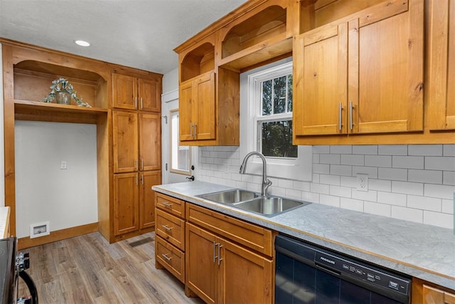 kitchen featuring backsplash, stainless steel range, sink, light hardwood / wood-style flooring, and dishwasher