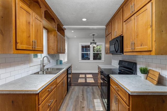 kitchen featuring black appliances, sink, light hardwood / wood-style flooring, decorative backsplash, and a textured ceiling