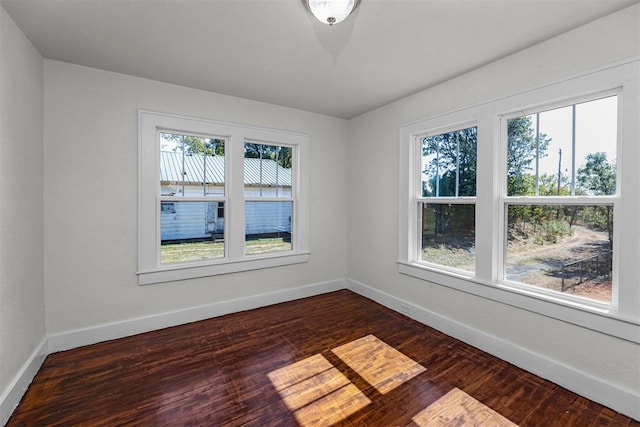 unfurnished room featuring dark hardwood / wood-style flooring and plenty of natural light