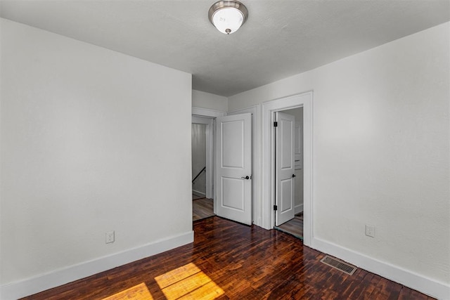 unfurnished bedroom with dark hardwood / wood-style floors