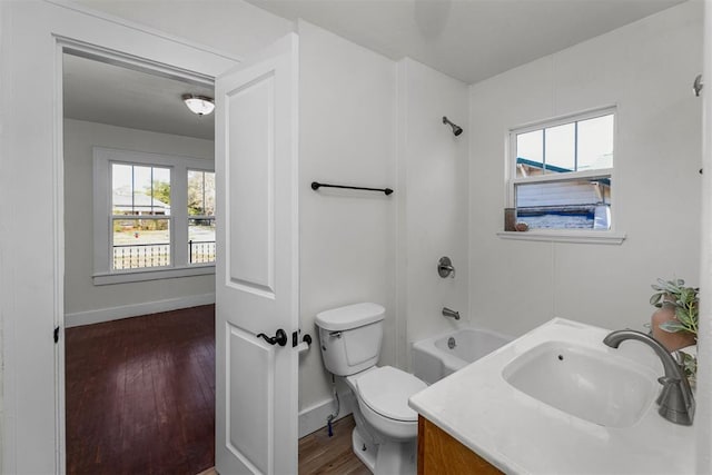 full bathroom featuring washtub / shower combination, hardwood / wood-style floors, vanity, and toilet