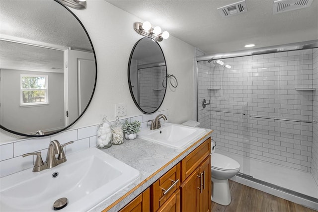 bathroom featuring tasteful backsplash, an enclosed shower, vanity, hardwood / wood-style flooring, and toilet