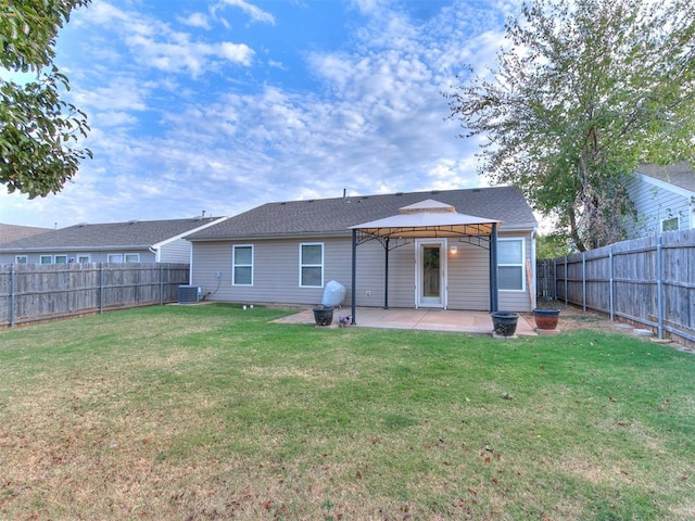 rear view of property with a gazebo, cooling unit, a patio, and a lawn