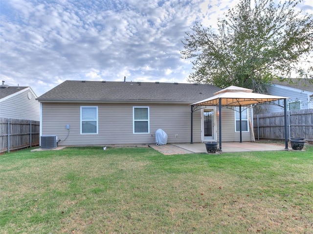 back of property with a gazebo, a patio area, and a lawn