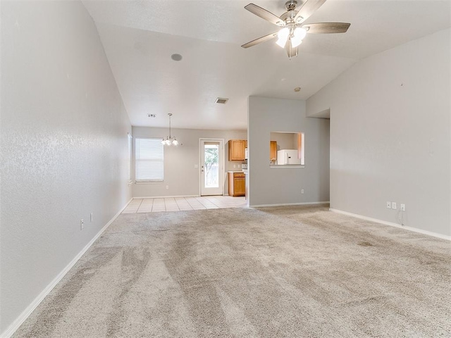 unfurnished living room featuring ceiling fan with notable chandelier, light colored carpet, and vaulted ceiling