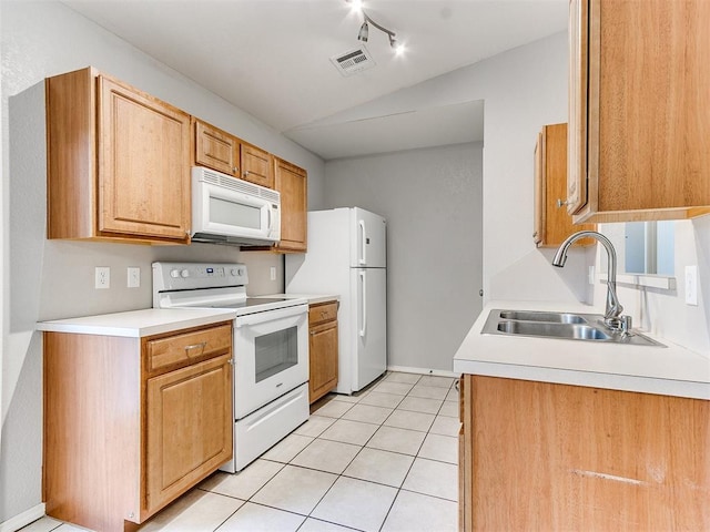 kitchen with light tile patterned floors, white appliances, and sink