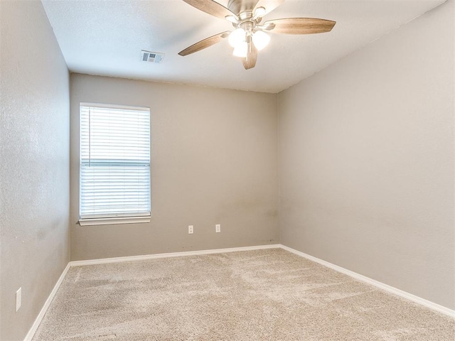 carpeted spare room featuring ceiling fan