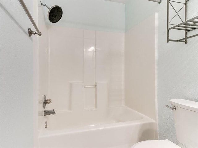 bathroom featuring shower / tub combination and toilet