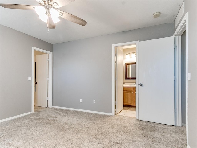 unfurnished bedroom featuring ceiling fan, light carpet, and connected bathroom