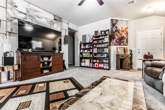 living room with ceiling fan, light colored carpet, and vaulted ceiling