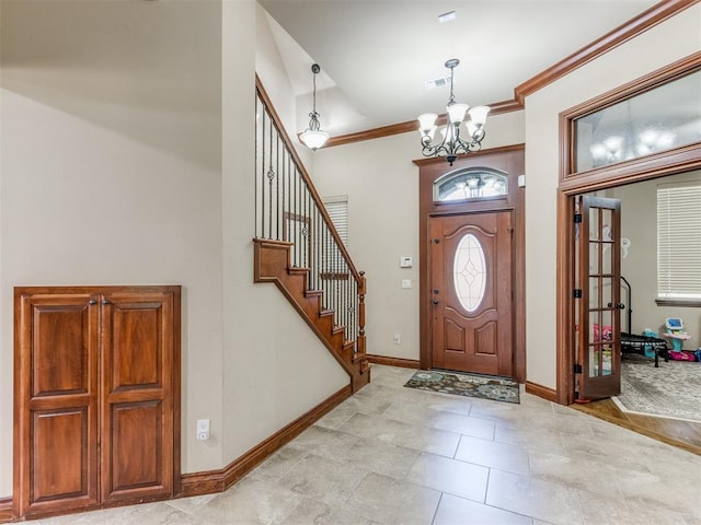 entrance foyer with a chandelier, light wood-type flooring, and crown molding