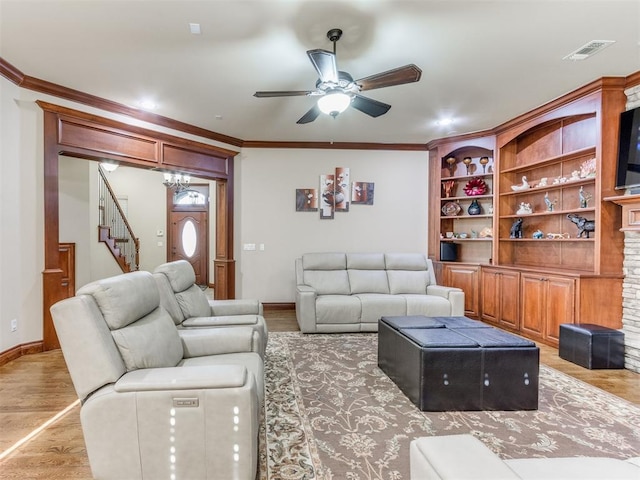 living room with crown molding, ceiling fan, and light wood-type flooring