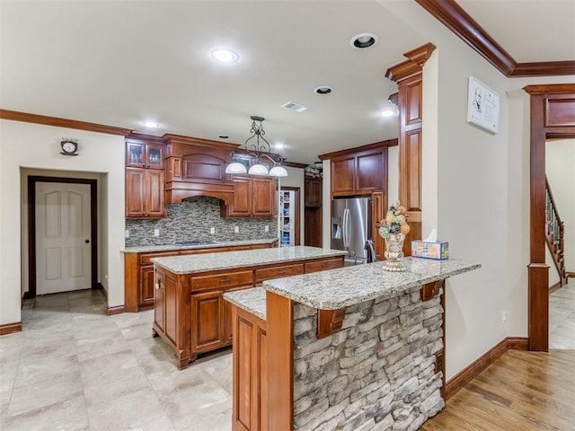 kitchen featuring pendant lighting, decorative backsplash, ornamental molding, appliances with stainless steel finishes, and kitchen peninsula