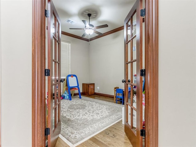 playroom with french doors, light hardwood / wood-style floors, ceiling fan, and ornamental molding