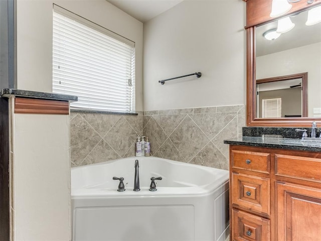 bathroom featuring a washtub and vanity