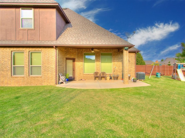 rear view of house with a playground, central air condition unit, a lawn, and a patio