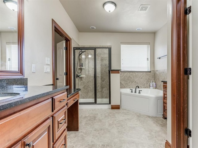 bathroom featuring a wealth of natural light, vanity, and independent shower and bath