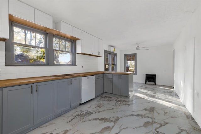 kitchen featuring a wood stove, gray cabinets, dishwasher, wood counters, and white cabinets