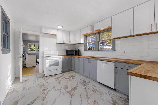 kitchen with white appliances, white cabinets, and wooden counters