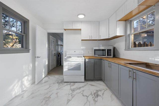 kitchen with gray cabinetry, white electric range oven, plenty of natural light, white cabinets, and wooden counters