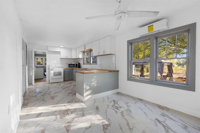 kitchen with a wall unit AC, a peninsula, electric range, decorative backsplash, and stainless steel microwave