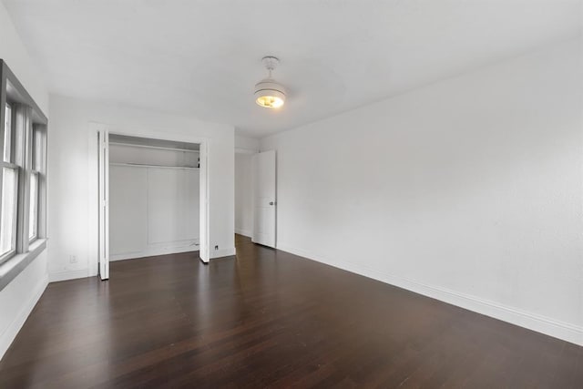 unfurnished bedroom featuring a closet, baseboards, and wood finished floors