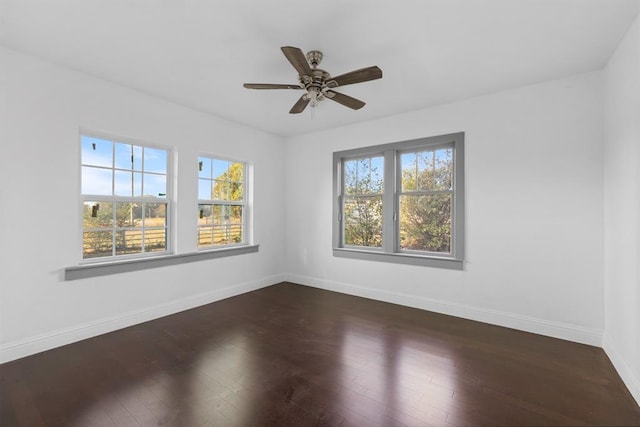 empty room featuring dark wood-style floors, ceiling fan, and baseboards