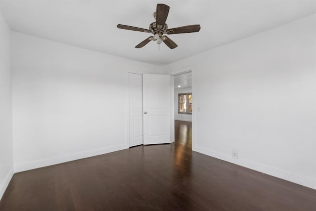 unfurnished room featuring dark wood-type flooring and ceiling fan