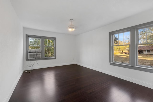 spare room with cooling unit, wood finished floors, and baseboards