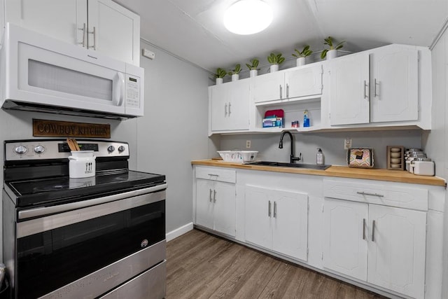 kitchen with white cabinetry, stainless steel range with electric cooktop, sink, dark wood-type flooring, and wooden counters