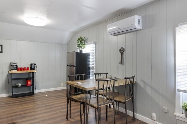 dining room featuring baseboards, vaulted ceiling, dark wood-style flooring, and a wall unit AC