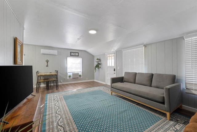 living room featuring hardwood / wood-style flooring, cooling unit, an AC wall unit, and lofted ceiling