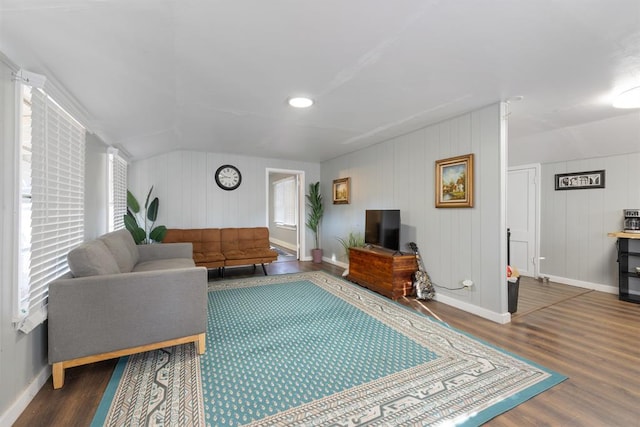 living area with vaulted ceiling, wood finished floors, and baseboards