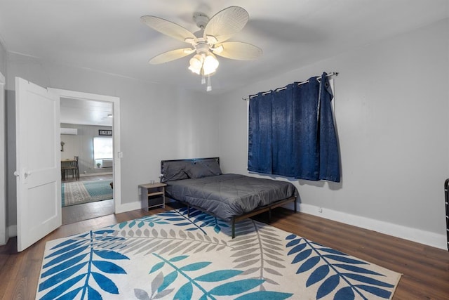 bedroom with ceiling fan, baseboards, and wood finished floors