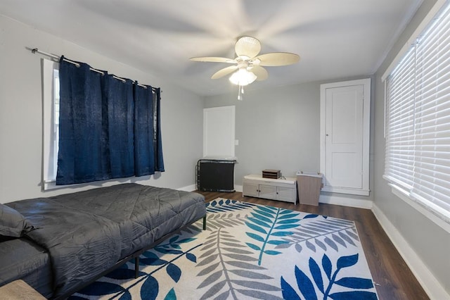 interior space with a wealth of natural light, baseboards, wood finished floors, and a ceiling fan