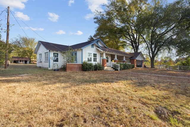 view of front of property featuring a porch, a front lawn, and fence