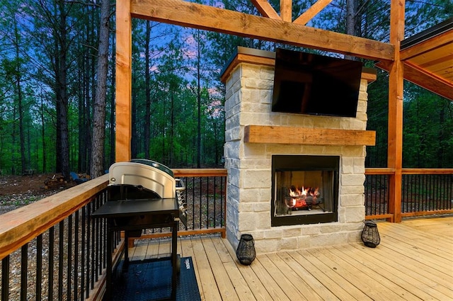 wooden terrace featuring an outdoor stone fireplace