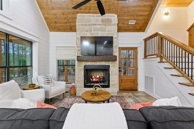 living room with wood-type flooring, wooden walls, wooden ceiling, and lofted ceiling