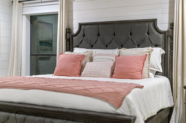 bedroom featuring wood walls