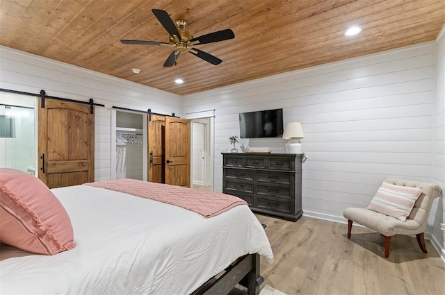 bedroom with a barn door, ceiling fan, wooden ceiling, and light wood-type flooring