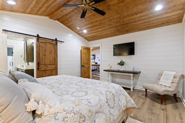 bedroom with connected bathroom, ceiling fan, wooden ceiling, a barn door, and light hardwood / wood-style floors