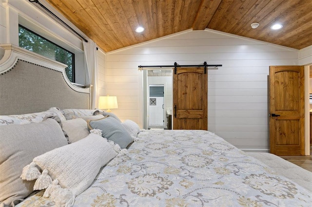 bedroom featuring wooden ceiling, wooden walls, vaulted ceiling, hardwood / wood-style flooring, and a barn door