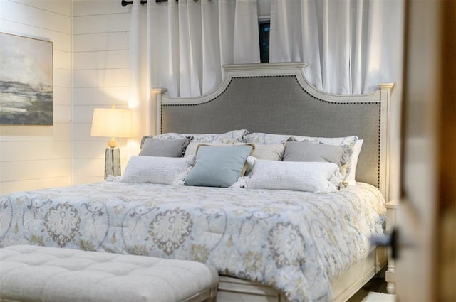 bedroom featuring wood walls