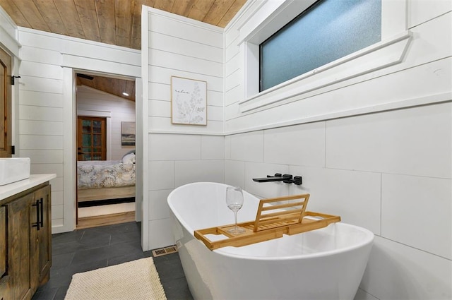 bathroom with vanity, wood walls, wooden ceiling, vaulted ceiling, and a washtub