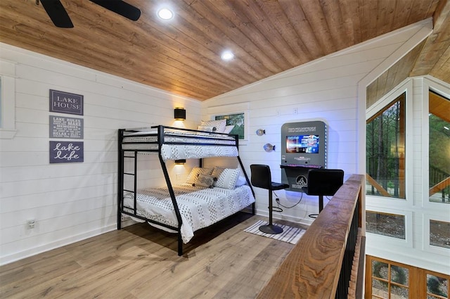 bedroom featuring hardwood / wood-style flooring, wooden ceiling, wooden walls, and vaulted ceiling