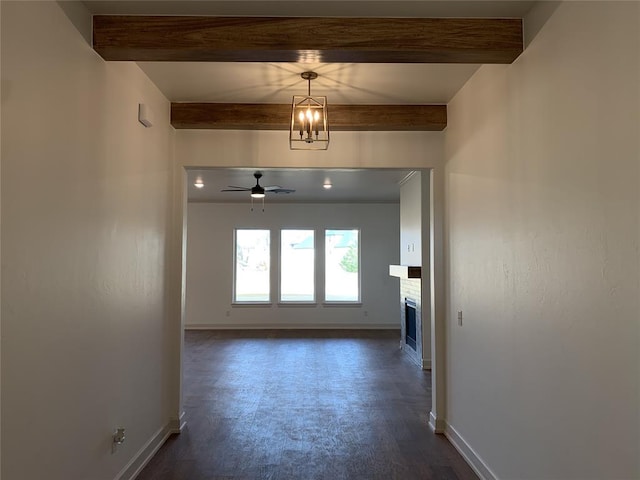 interior space with beamed ceiling, ceiling fan with notable chandelier, and dark wood-type flooring