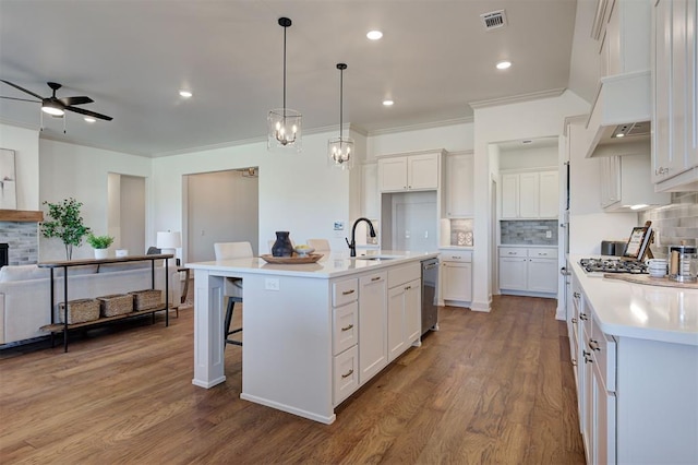 kitchen with visible vents, open floor plan, light countertops, white cabinetry, and a sink