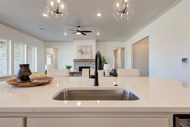 kitchen featuring open floor plan, a fireplace, a sink, and visible vents